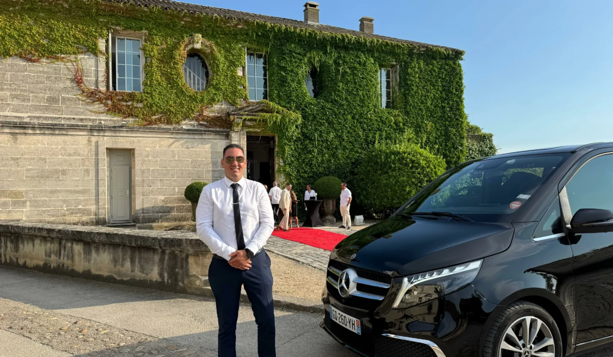 Chauffeur privé de DreamCarSud en tenue professionnelle devant un domaine de prestige avec véhicule Mercedes V-Class, lors d’un événement haut de gamme près de Montpellier