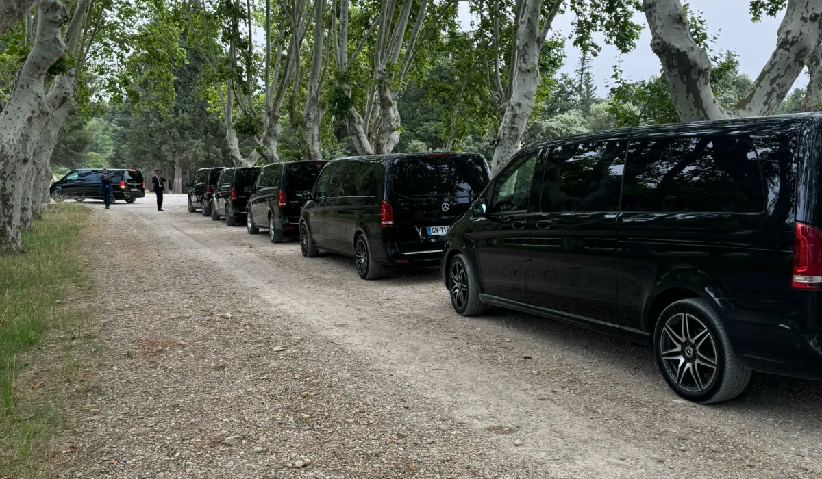File de vans VTC Mercedes noirs garés sous des platanes dans un domaine du sud de la France, dans le cadre d’un événement privé ou professionnel organisé par DreamCarSud