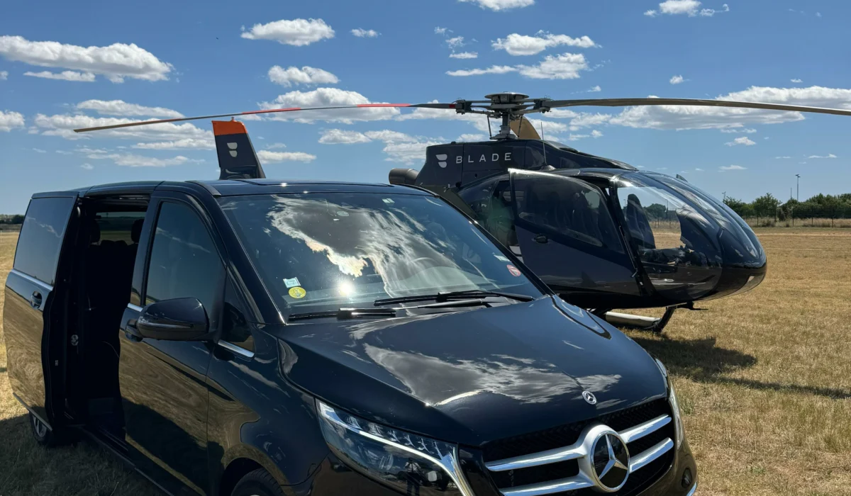 Van Mercedes DreamCarSud VTC garé sur piste avec un hélicoptère Blade, symbolisant un service de transfert VIP personnalisé et premium à Montpellier ou sur le pourtour méditerranéen