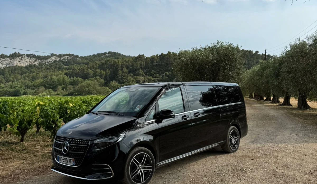 Véhicule VTC Mercedes noir stationné dans un décor naturel de vignes et de garrigue près de Montpellier, idéal pour excursions et circuits touristiques en Occitanie